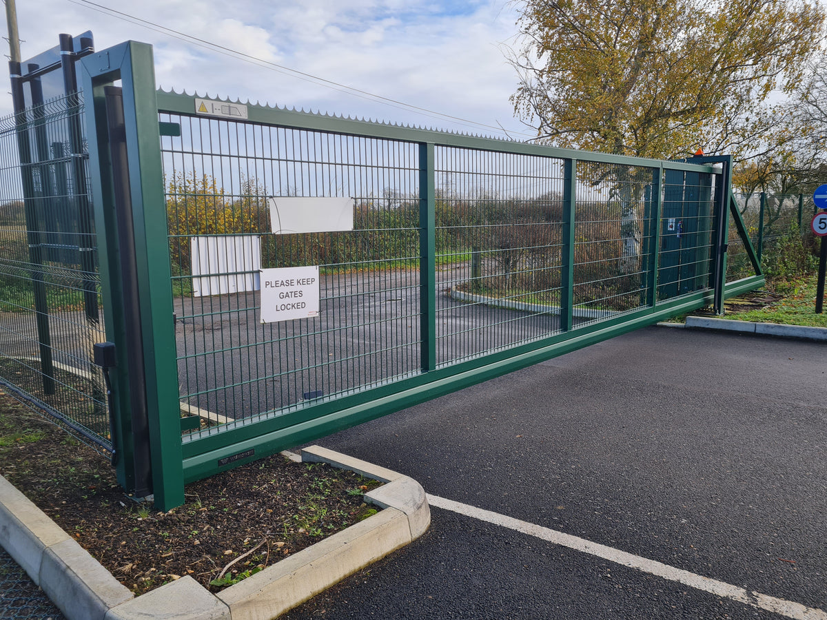 Green mesh cantilever sliding gate at a commercial car park