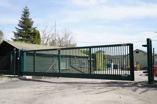 Green cantilever sliding gate at an industrial site entrance