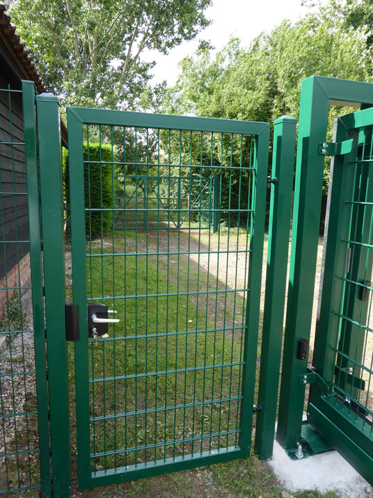 Green mesh pedestrian gate in security fencing